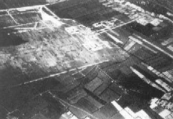 10 mei 1940 's ochtends genomen Nederlandse verkenningsfoto van Valkenburg. Ju-52s en parachutisten (witte stippen) zijn te herkennen.