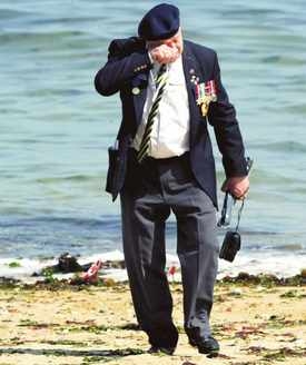 Het verdriet blijft. Geëmotioneeerd loopt een veteraan zestig jaar na de geallieerde invasie van Normandië over het strand van Juno Beach.